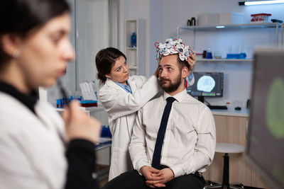 Side view of doctor examining patient at clinic