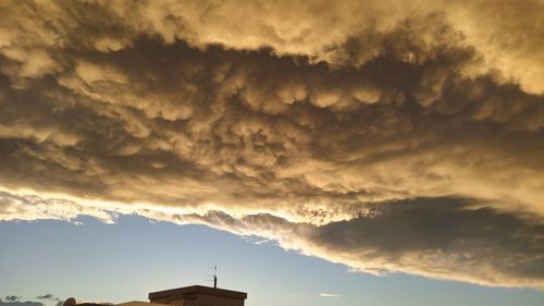 Low angle view of storm clouds over buildings