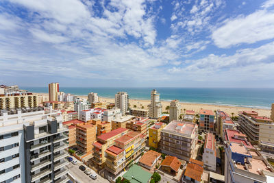 High angle view of buildings by sea against sky