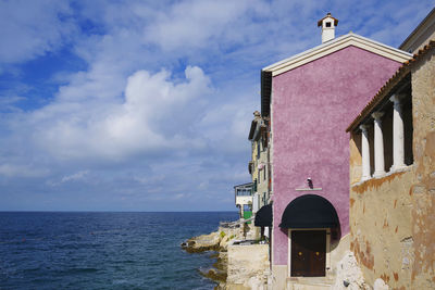 Building by sea against sky