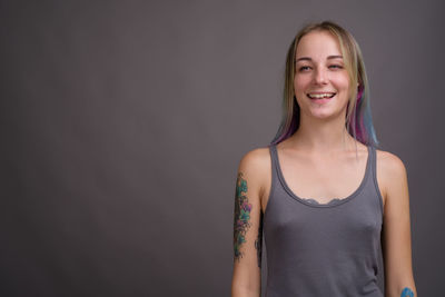 Portrait of a smiling young woman against black background