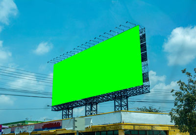 Low angle view of signboard against blue sky