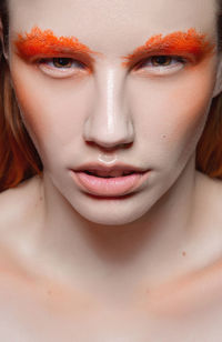Close-up portrait of serious young woman with orange eyebrows
