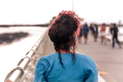 Rear view of woman standing against sky