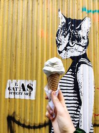 Full length of hand holding ice cream cone