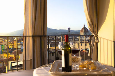 Glass of wine on table at restaurant against sky