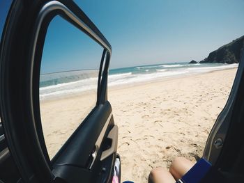 Cropped image of person sitting in car at beach