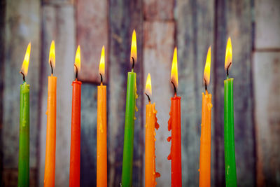 Close-up of burning multi colored candles