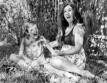 Mother and son enjoying while sitting on grass