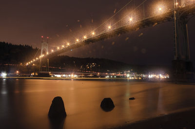 Illuminated bridge against sky at night