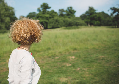 Side view of woman standing on grassy field