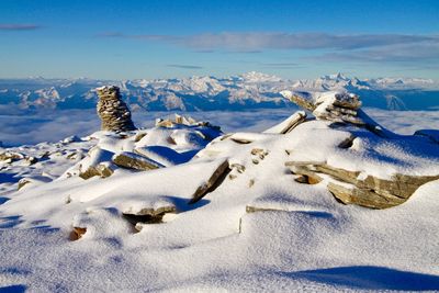 Snow covered land and sea against sky