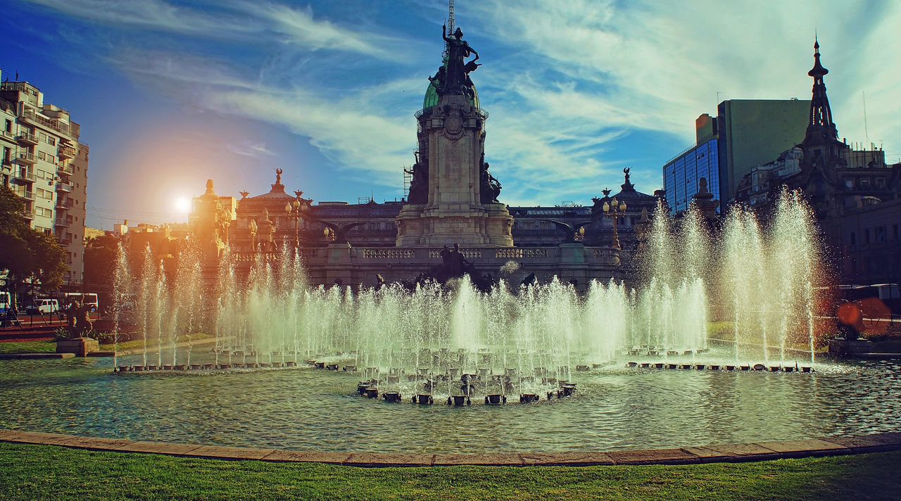 FOUNTAIN IN CITY AGAINST SKY DURING RAINY SEASON