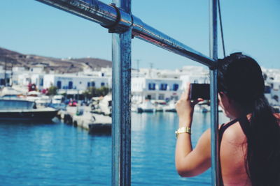 Rear view of woman photographing on sea