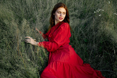 Portrait of young woman standing against mountain