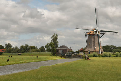 Traditional windmill on field against sky