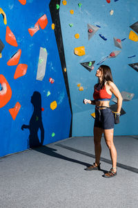 Young woman preparing the ascent towards an indoor climbing wall