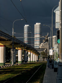 Train at railroad station in city against sky
