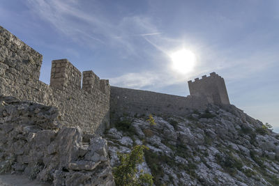 Low angle view of castle against cloudy sky