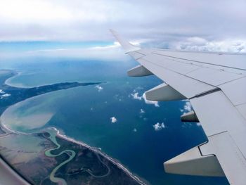 Aerial view of aircraft wing against sky