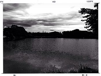 Scenic view of river against cloudy sky