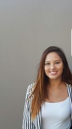 Portrait of smiling young woman against white background