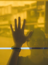 Young man seen through yellow glass window