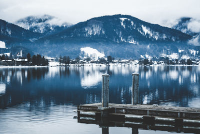 Scenic view of lake by snowcapped mountains against sky