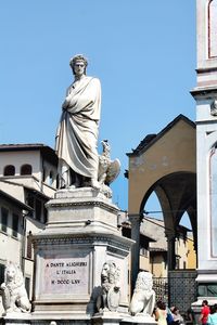 Low angle view of statue against historic building against clear sky