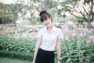 Side view of young woman standing on field