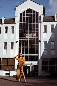 Full length of woman standing against building