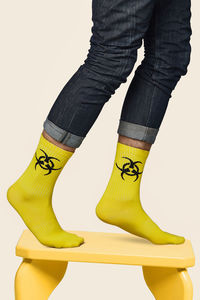 Low section of person standing against yellow background