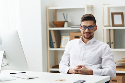 Portrait of smiling businessman desk in office