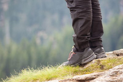 Low section of man standing on rock