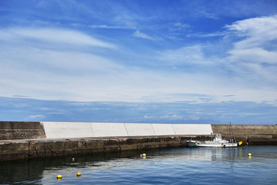 Scenic view of sea and harbor against blue sky