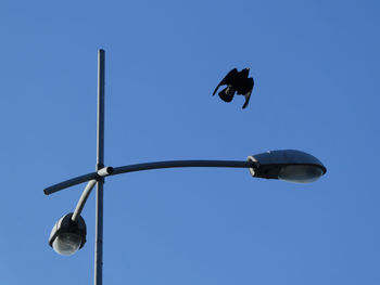 Low angle view of street light against blue sky