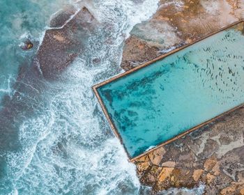 Aerial view of swimming pool by sea 