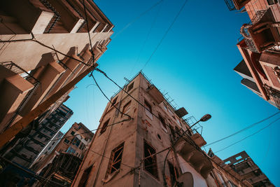 Low angle view of buildings against clear blue sky