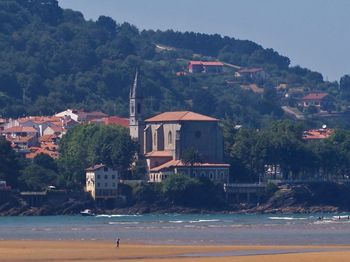 Scenic view of beach by buildings in town