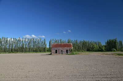 Built structure on landscape against blue sky