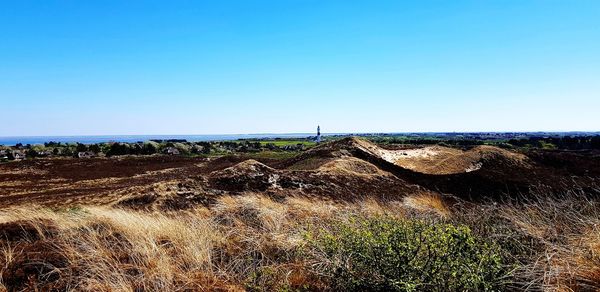 Scenic view of field against clear blue sky