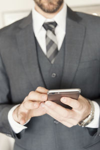 Midsection of man using mobile phone