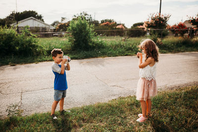 Siblings standing on field