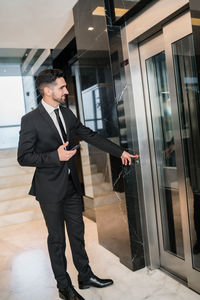 Full length of a young man looking through window