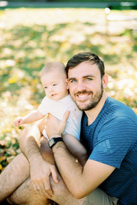 Portrait of young man sitting on field