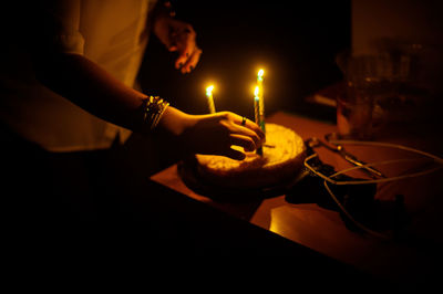 Close-up of woman hand on illuminated table