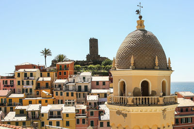 Scenic view of town next to sea against clear sky