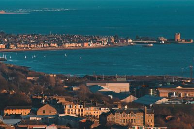 High angle view of city by sea against sky