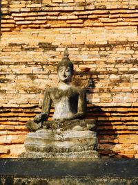 Statue against brick wall