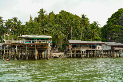 Built structure by river against sky